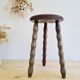 Antique tripod stool with turned wooden legs and leather seat.