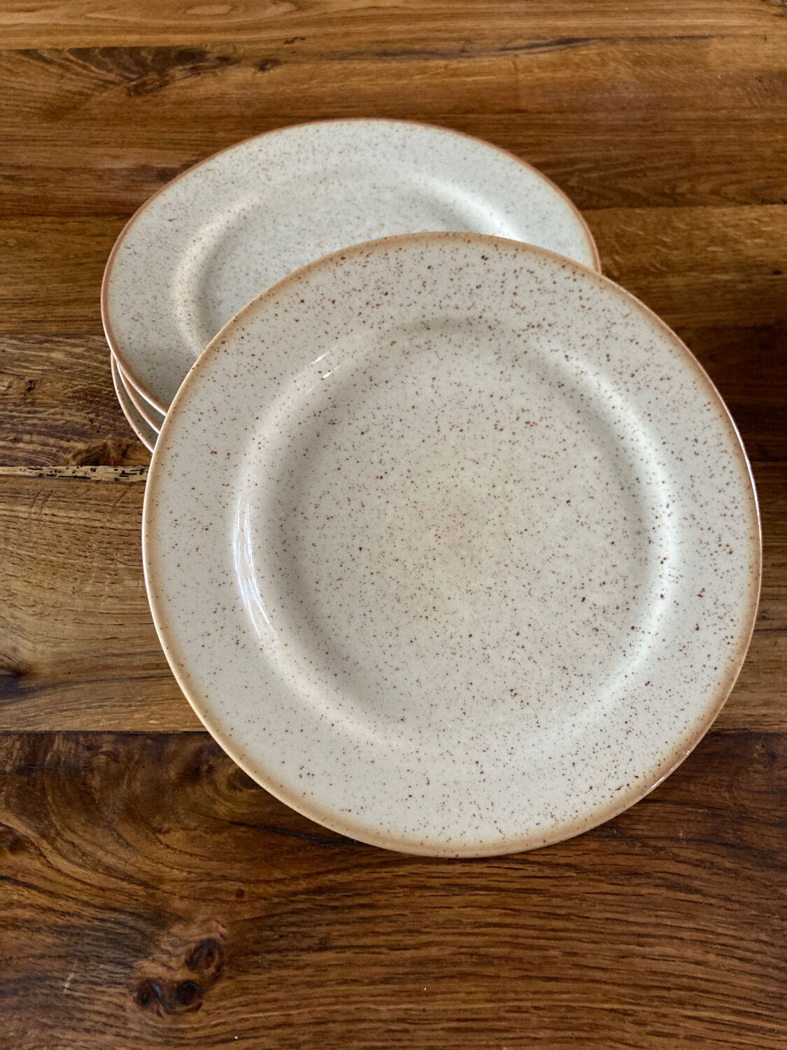 Four beige speckled plates