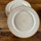 Four beige speckled plates