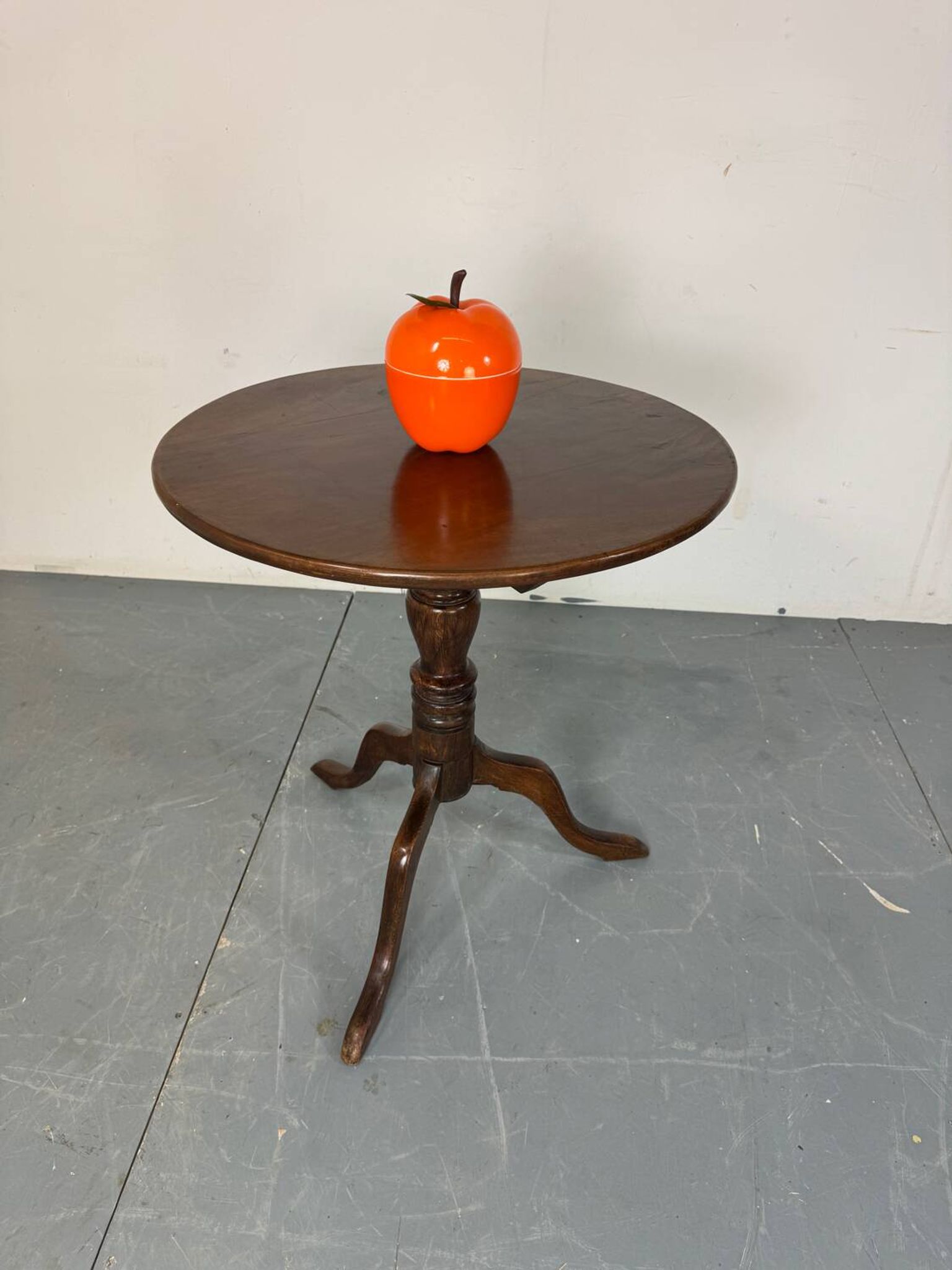 Round coffee table with an adjustable top in antique mahogany.