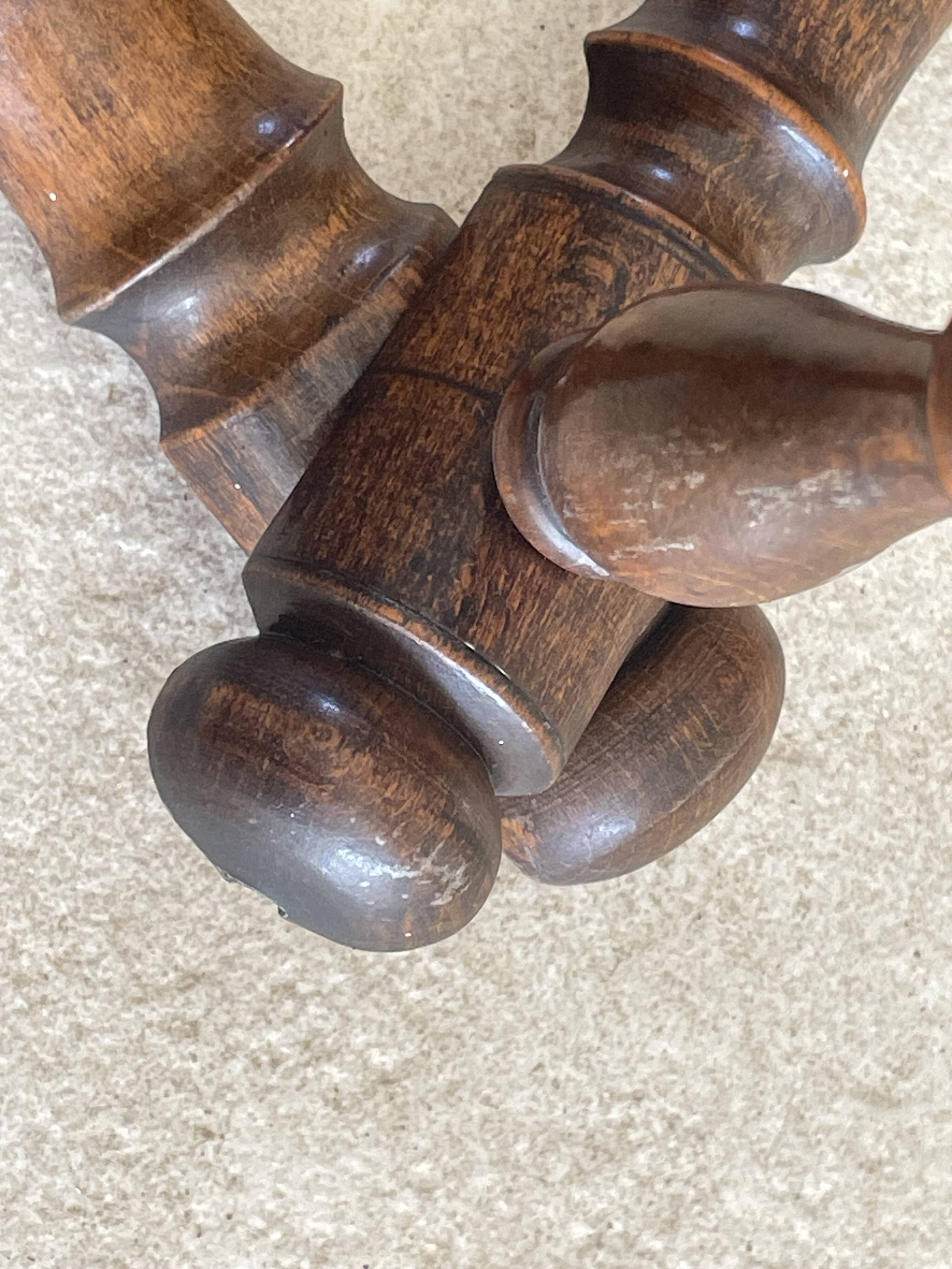 Wall-mounted accordion coat rack made of turned wood