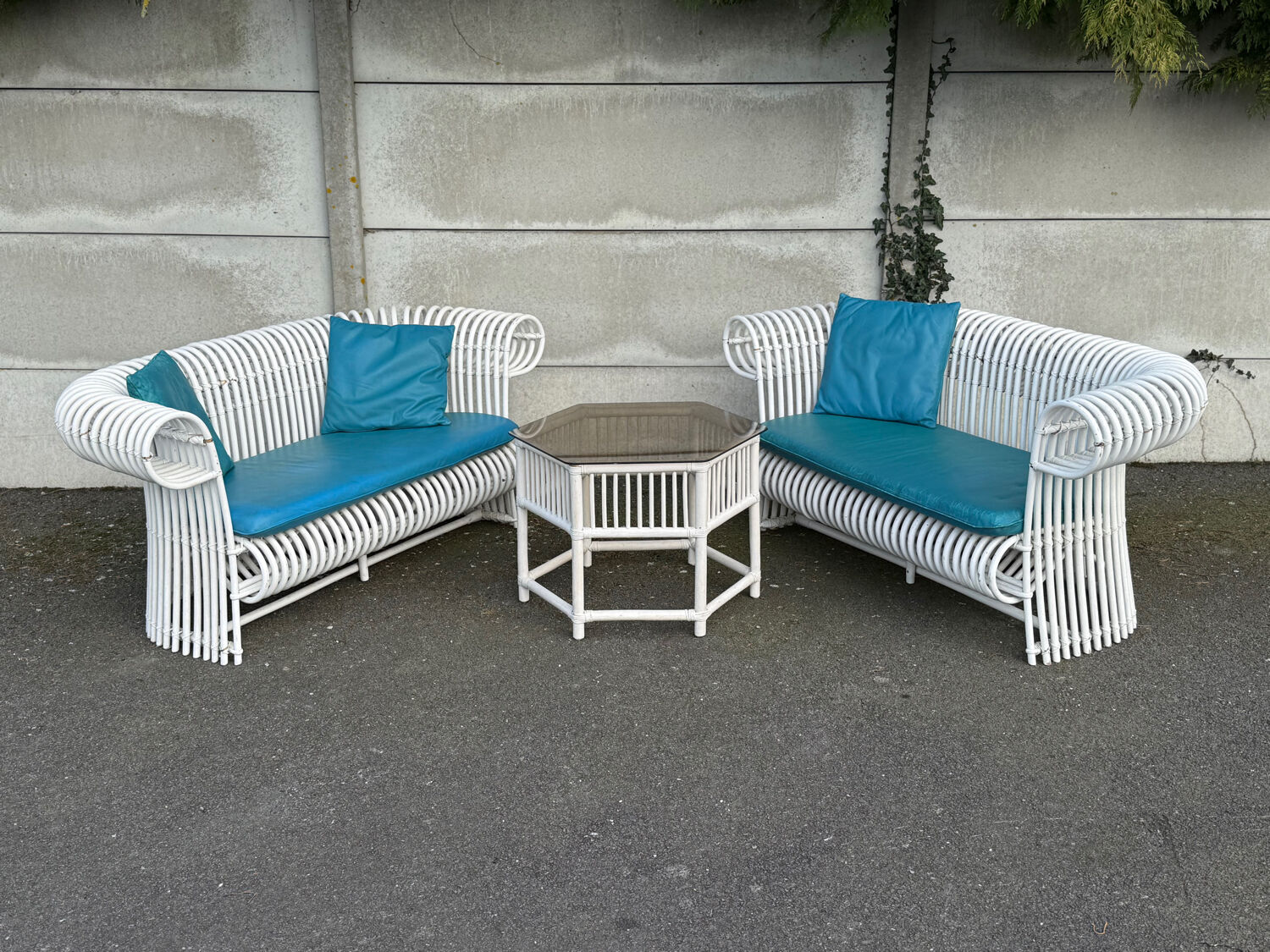 Rattan lounge with two two-seater sofas and a white coffee table.