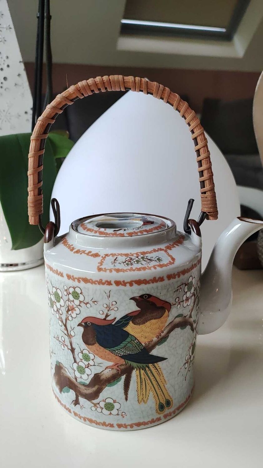 Japanese ceramic teapot. bird/paradise motifs/cherry trees. bamboo/rattan braided handle