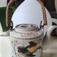 Japanese ceramic teapot. bird/paradise motifs/cherry trees. bamboo/rattan braided handle