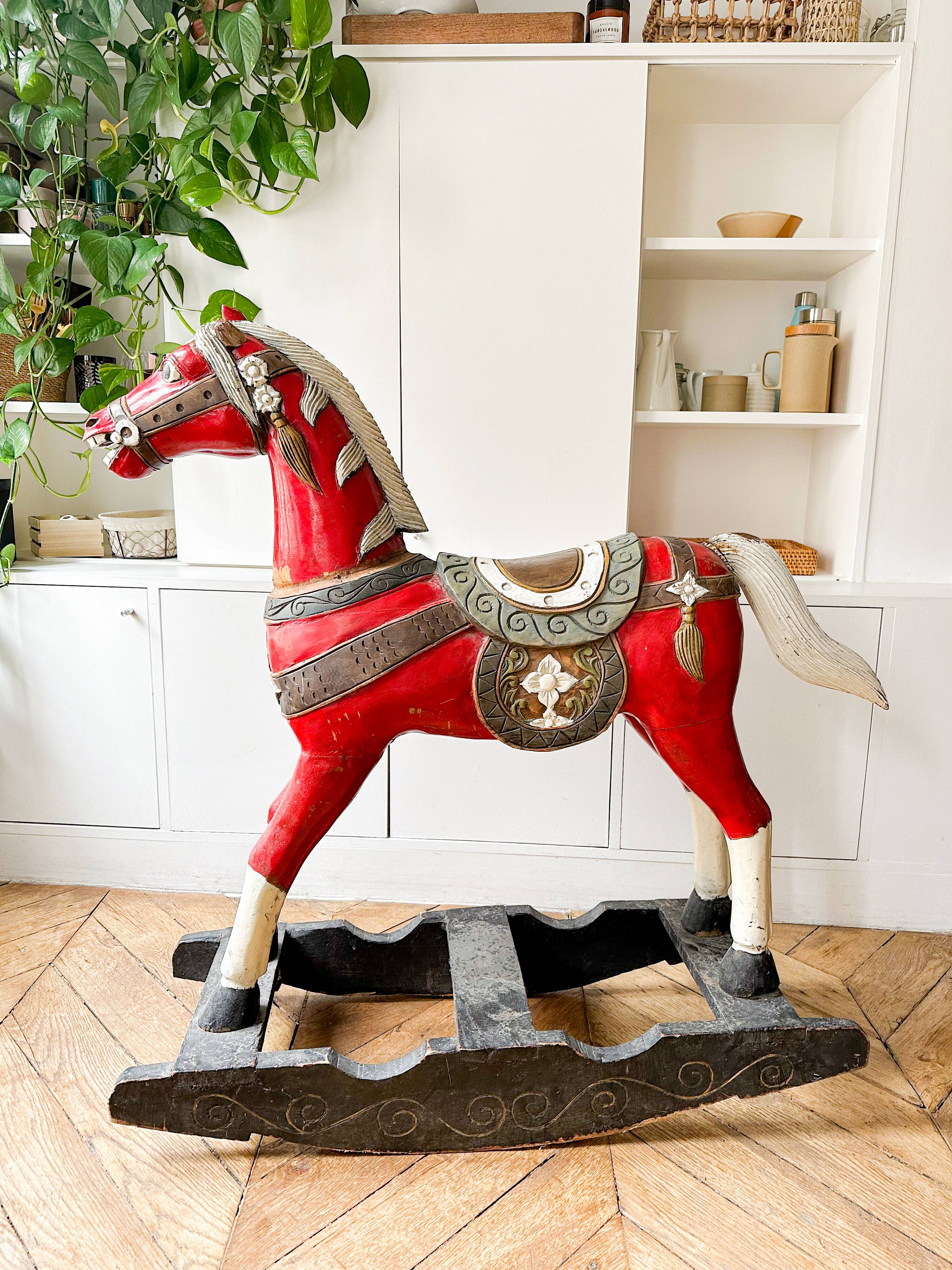 Large decorative rocking horse made of carved and hand-painted wood.