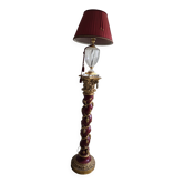 red and gold wooden column in the shape of a vine foot topped with a lamp