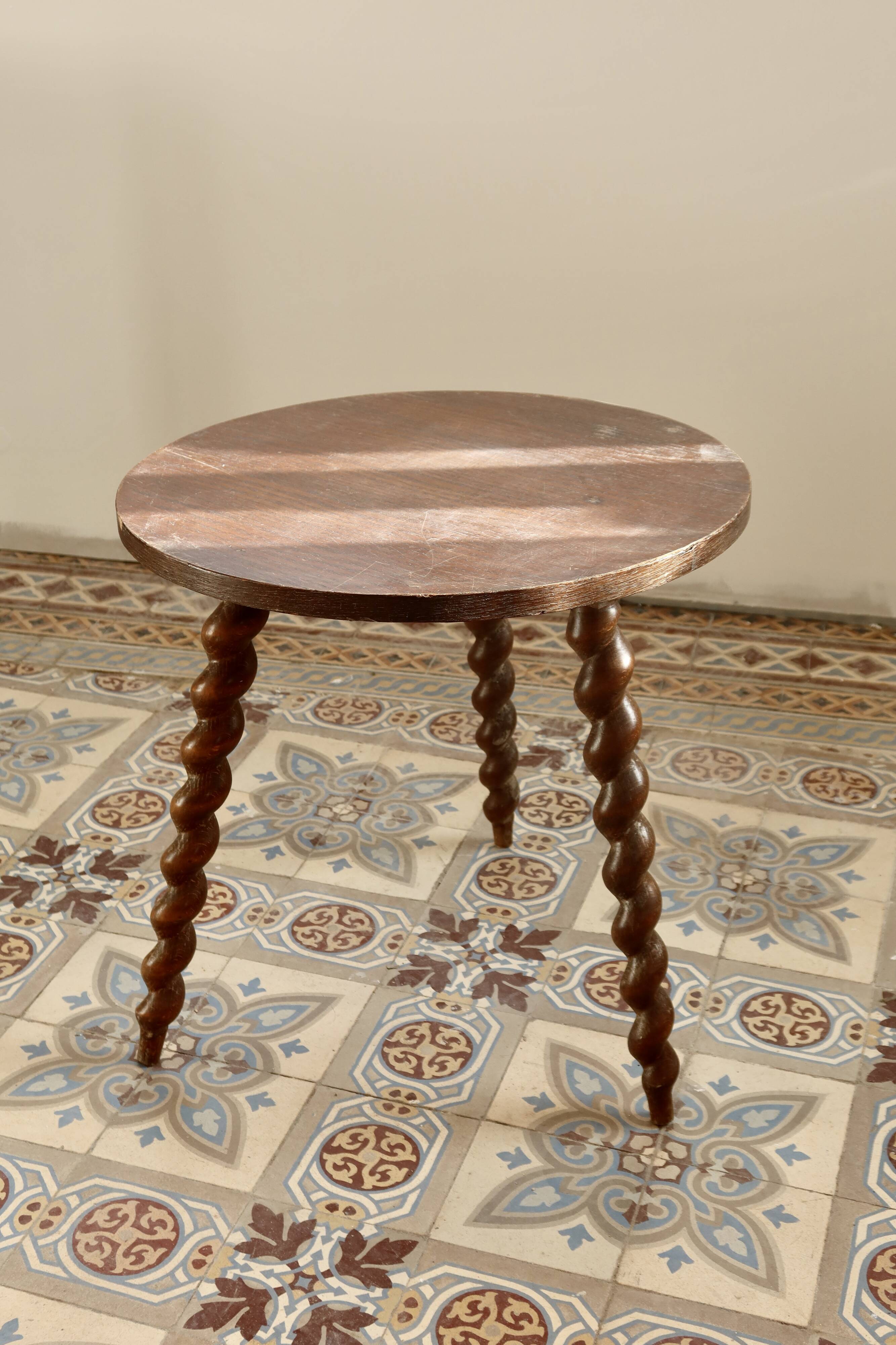 Vintage circular side table in wood with turned legs.