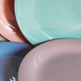 Seven pastel-colored plates mixed with vintage earthenware