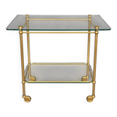 Service trolley on wheels with two glass shelves and a brass frame.