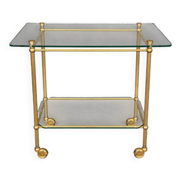 Service trolley on wheels with two glass shelves and a brass frame.