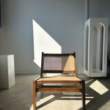 Reclined armchair in canned teak in natural wood