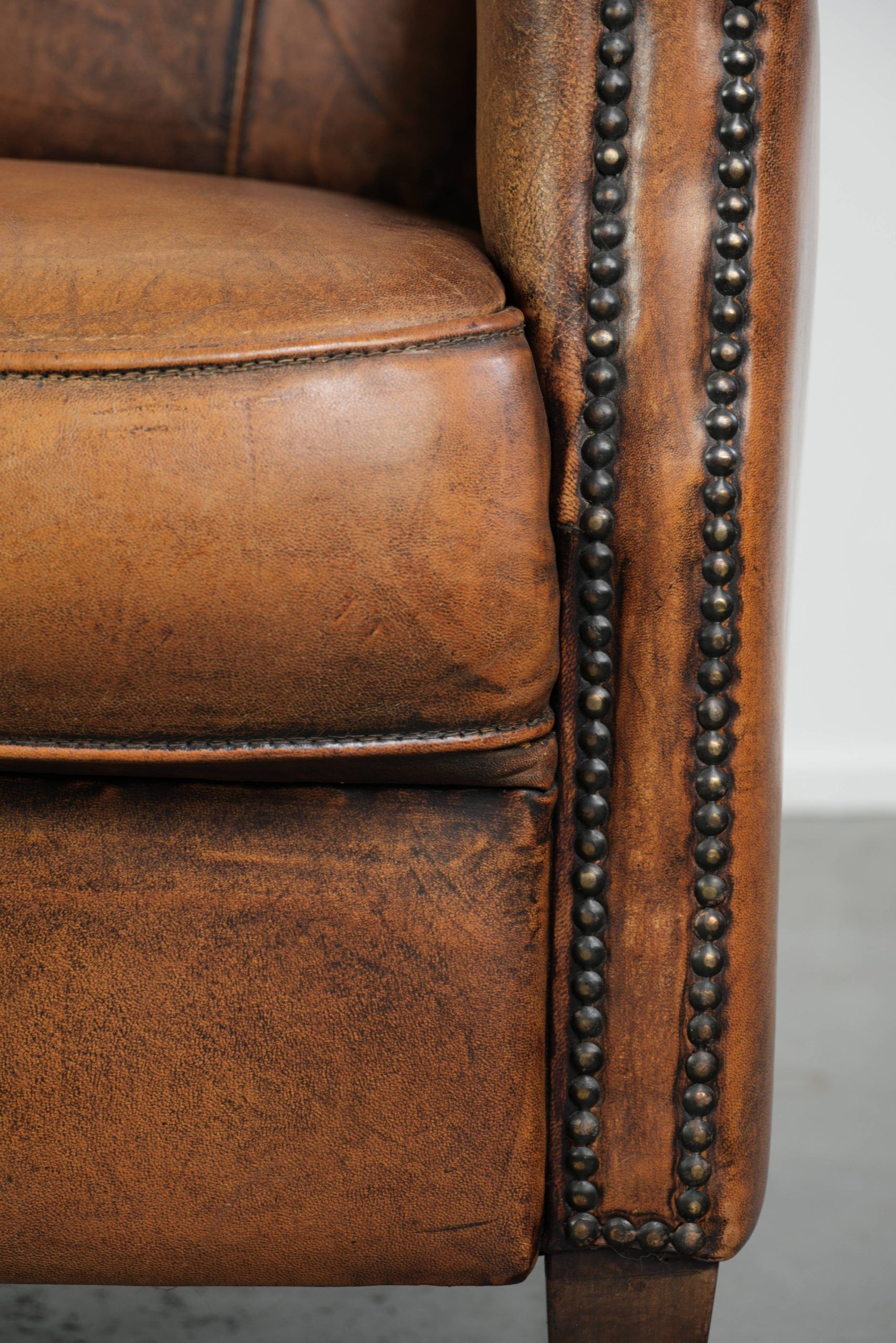 Comfortable characterful sheepskin armchair finished with decorative nails