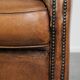 Comfortable characterful sheepskin armchair finished with decorative nails