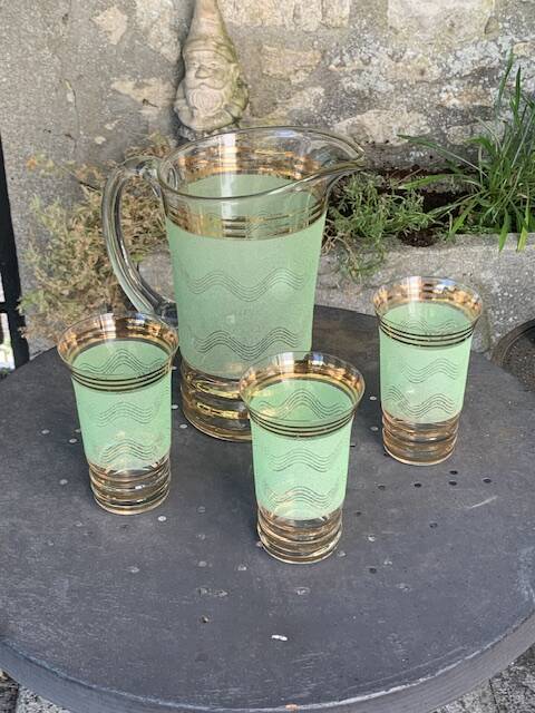 Serve an orangeade, a carafe and 3 glasses in green granite with golden trim.