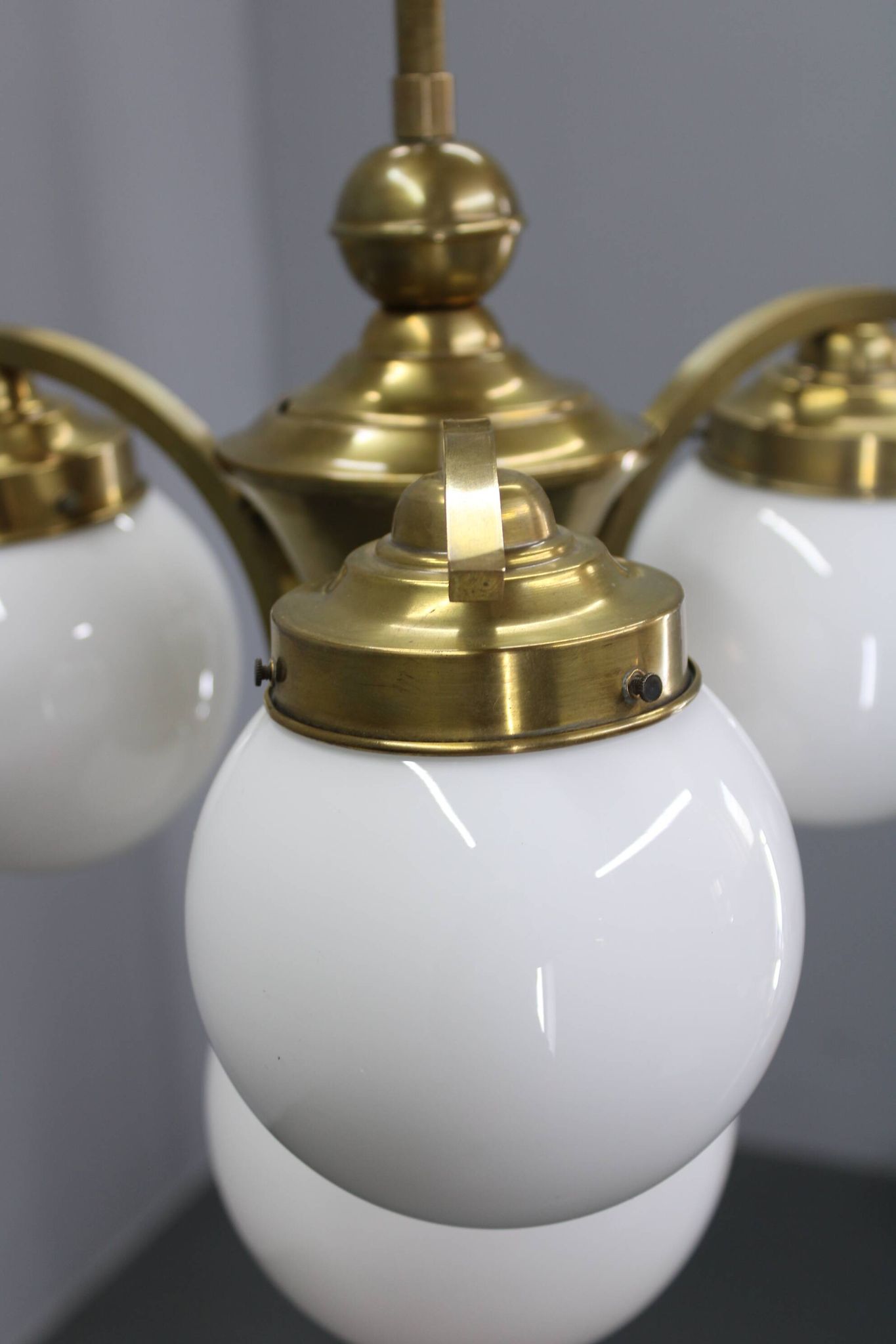 1930s Czechoslovak Art Deco brass chandelier with four opaline glass globes