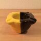Two-tone ceramic ashtray in yellow and black, vintage 1950s.