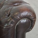 Old dark brown 3-seater cowhide chesterfield sofa with lots of character