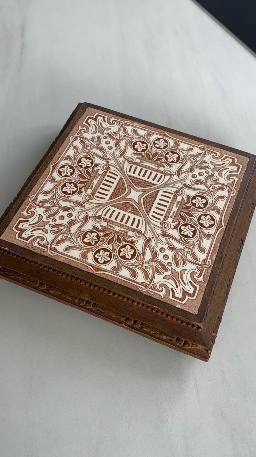 Vintage wooden and antique earthenware trivet, brown tile design