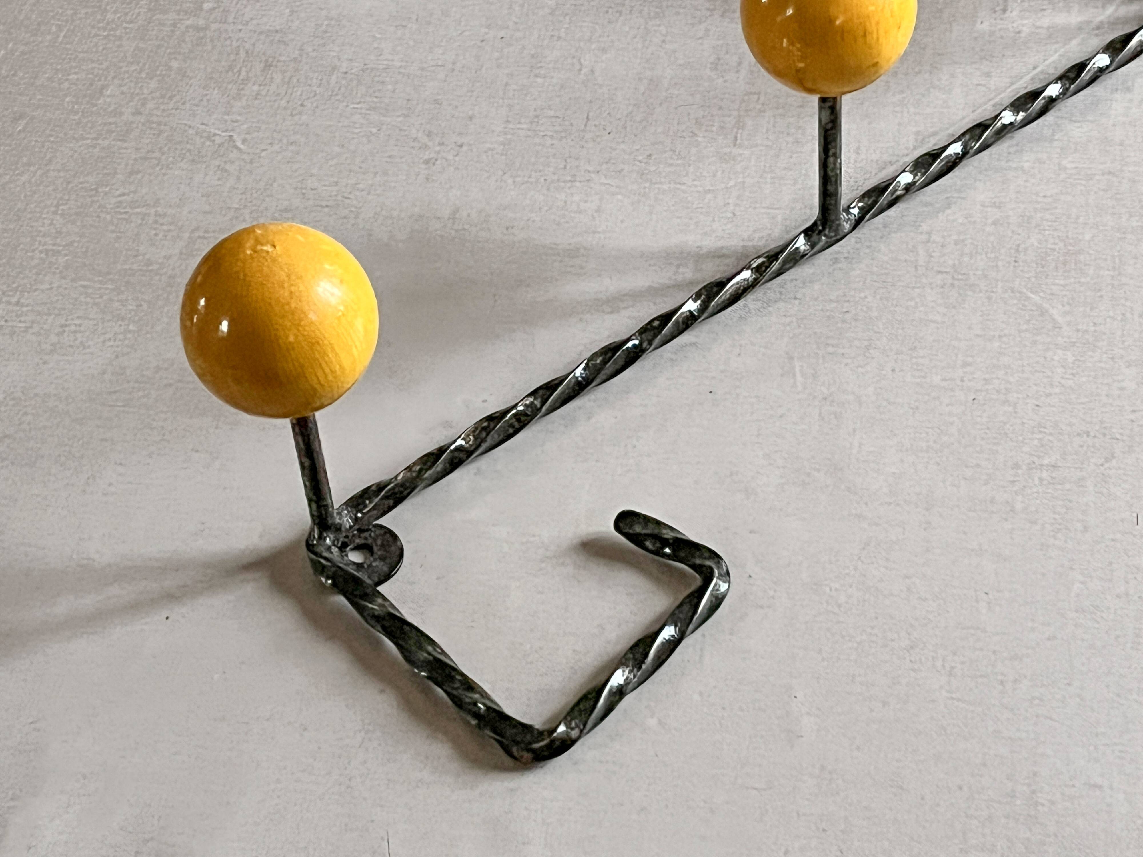 Wall-mounted coat rack in metal and wood with 3 hooks, antique item.