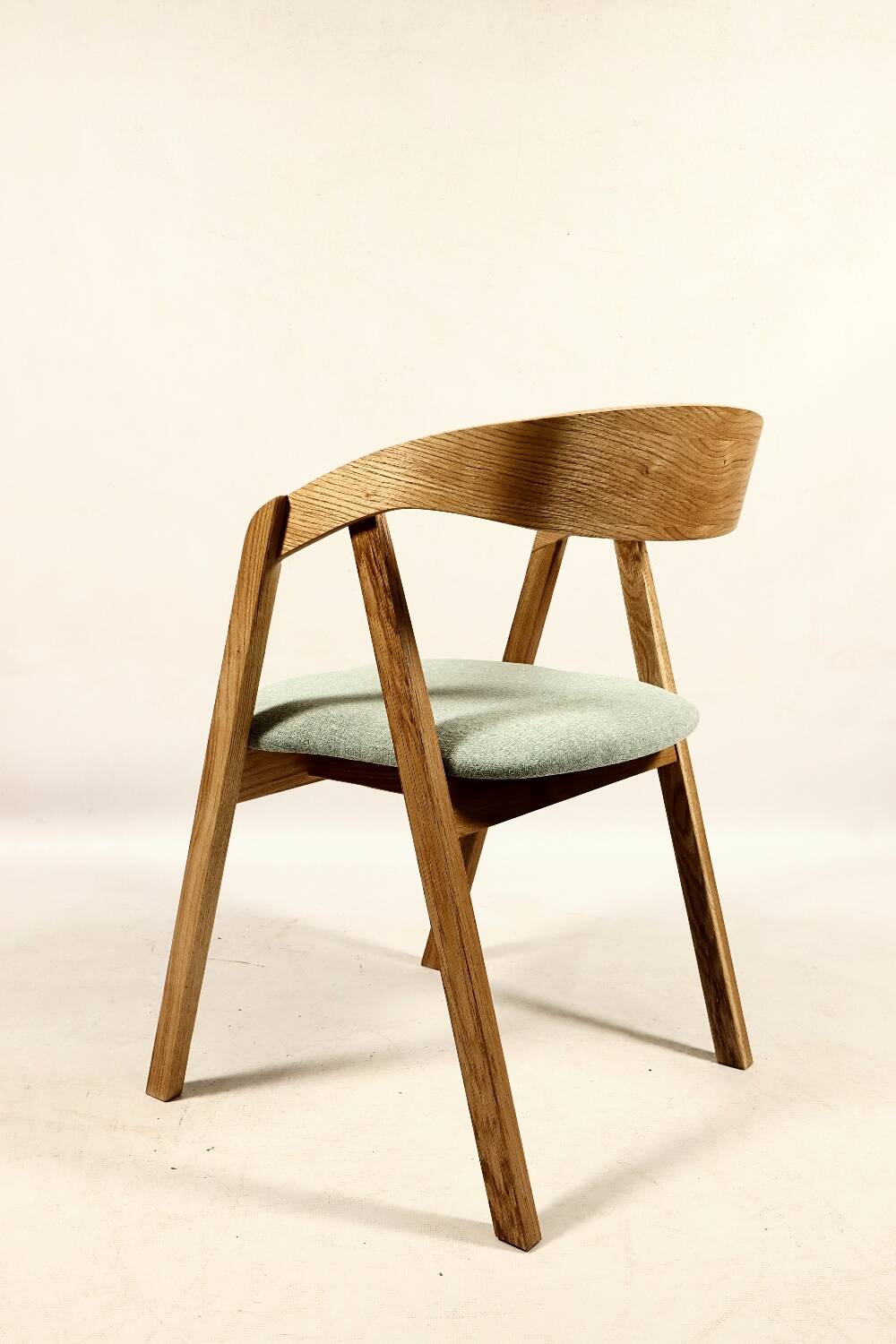 Vintage dining chair in light oak with natural linen pastel green fabric.