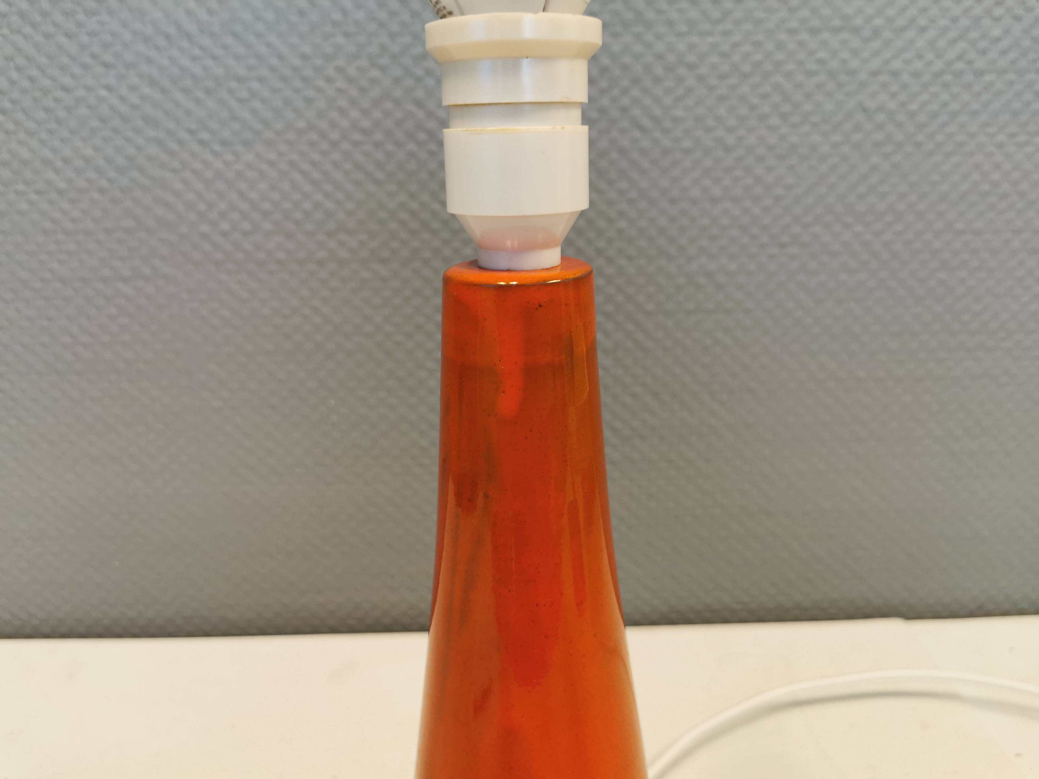 Ceramic table lamp with partial orange glaze.