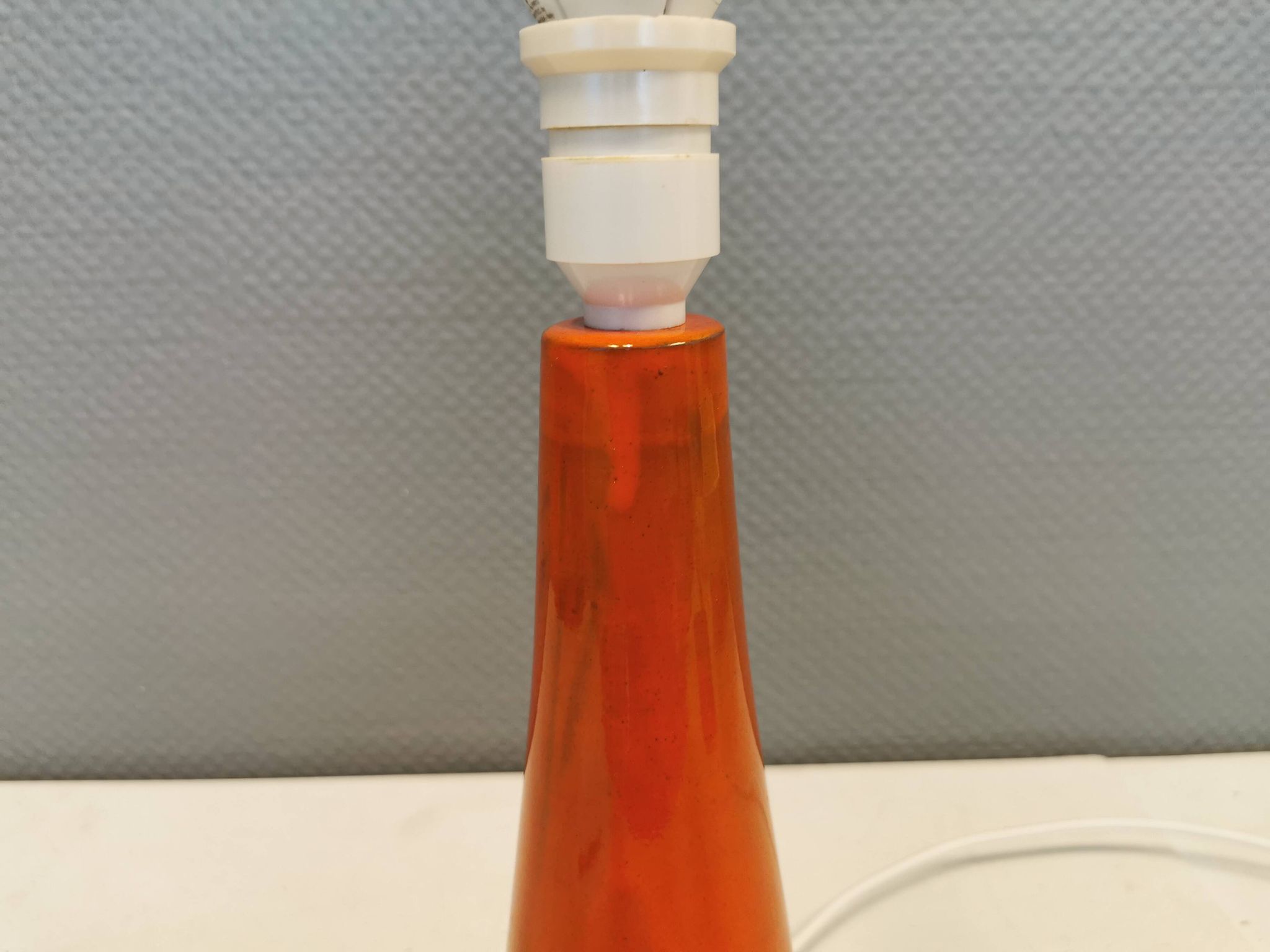 Ceramic table lamp with partial orange glaze.