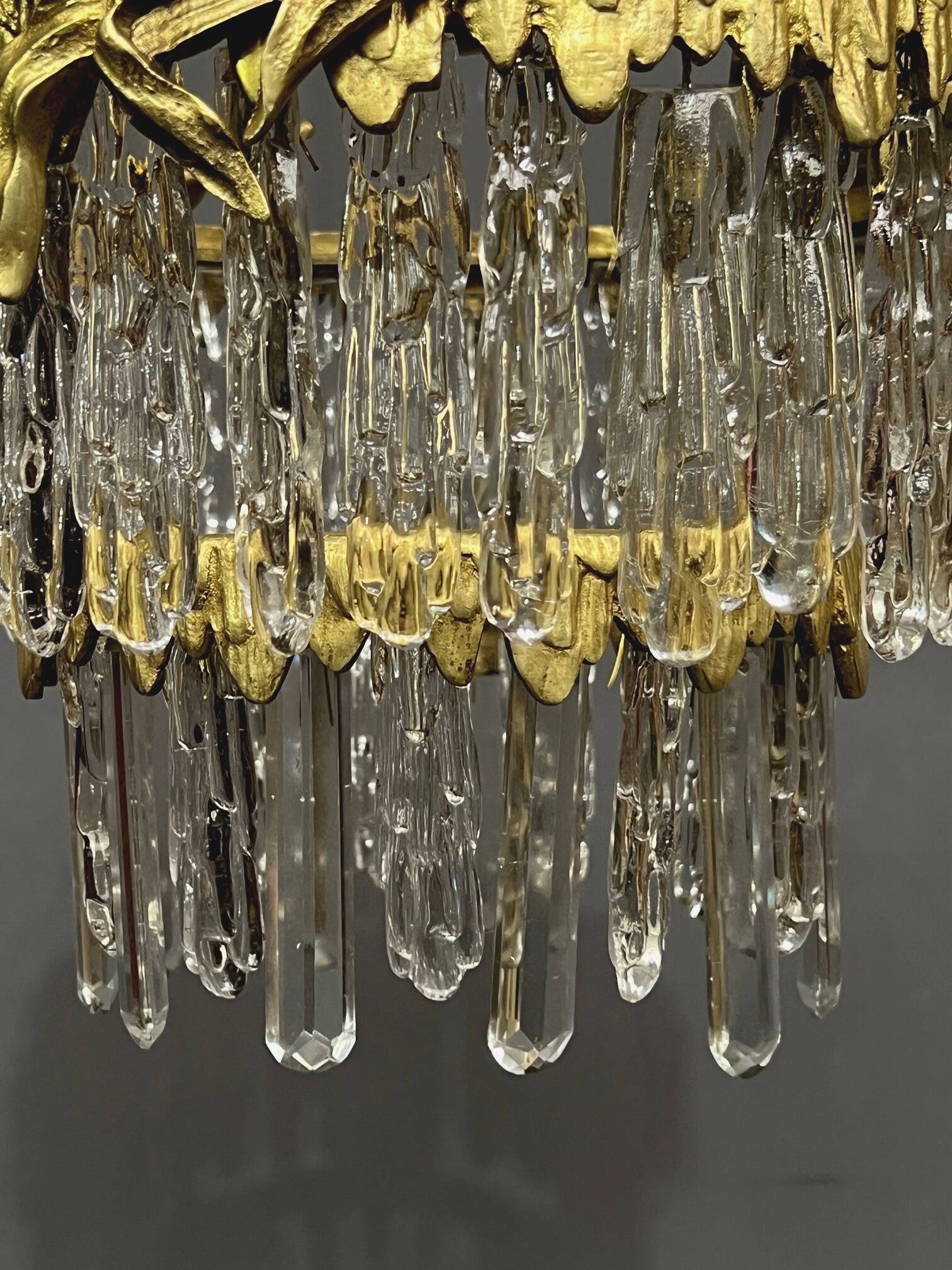 Antique chandelier in gilded bronze with crystal pendants.