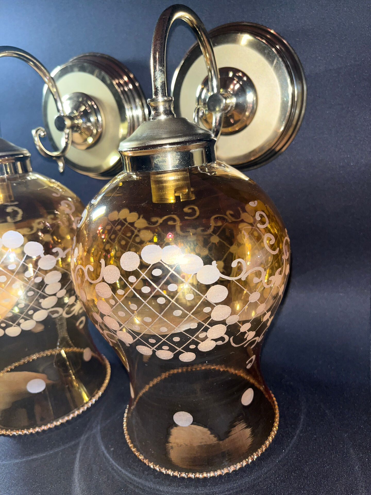 Pair of vintage wall sconces in brass with amber glass globes.