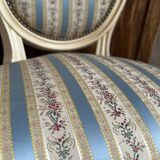 Pair of Louis XVI style chairs in painted wood and satin, classic elegance.