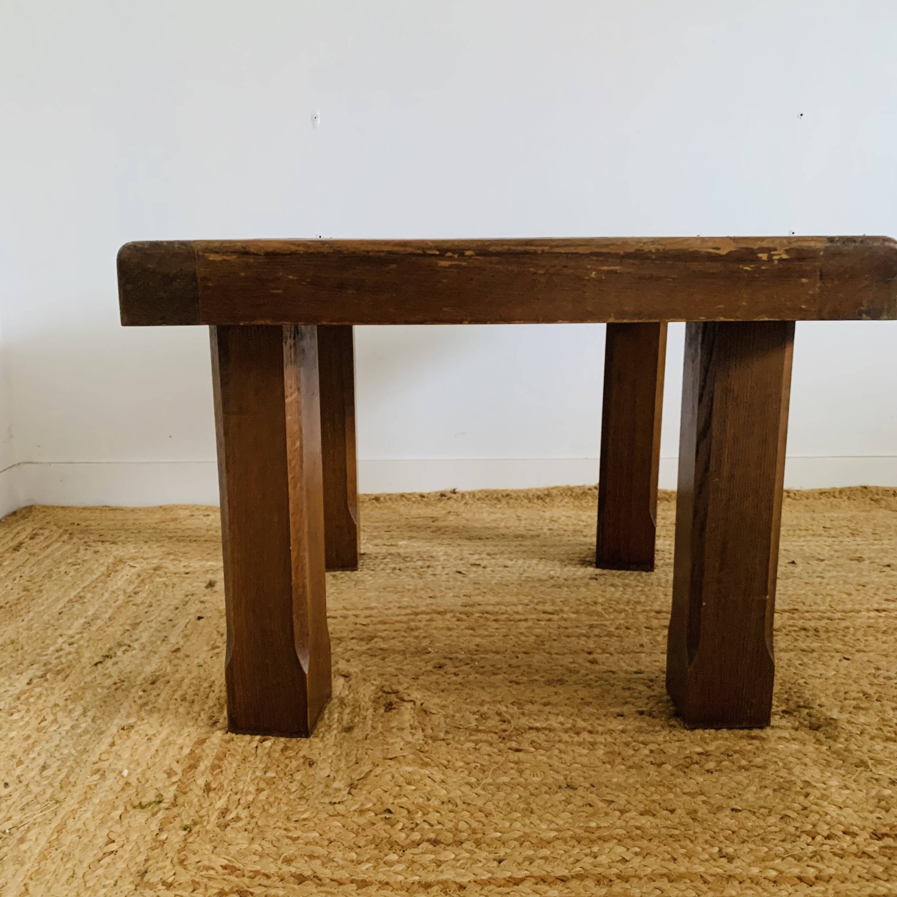 Square table with red tiles signed.