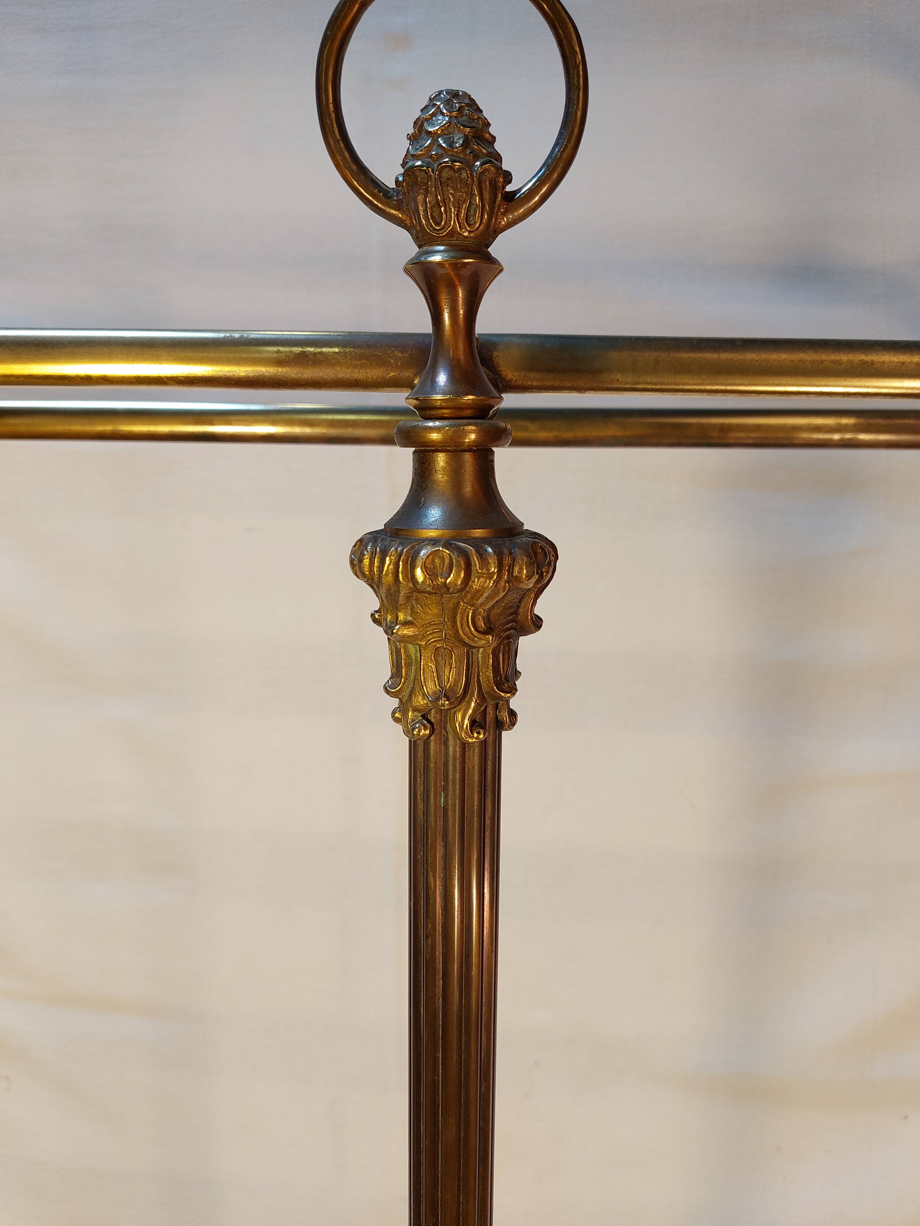 Old golden brass towel rack on baroque style foot