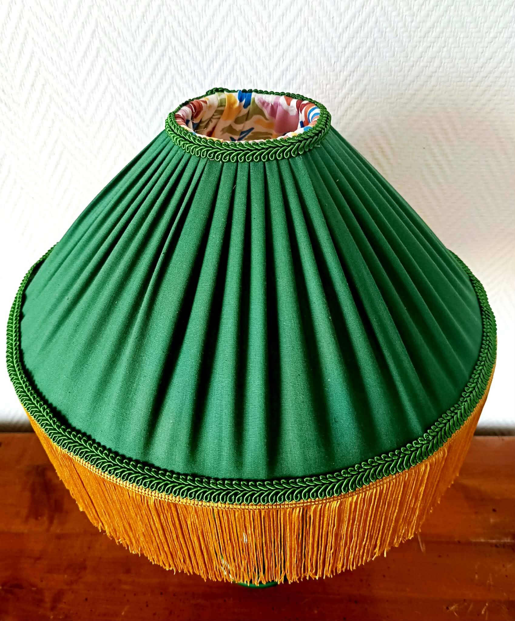 Green ceramic lamp with a vintage pleated fringe shade.