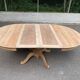 Round dining table with a central pedestal, extendable, stripped in solid walnut with 2 extensions.