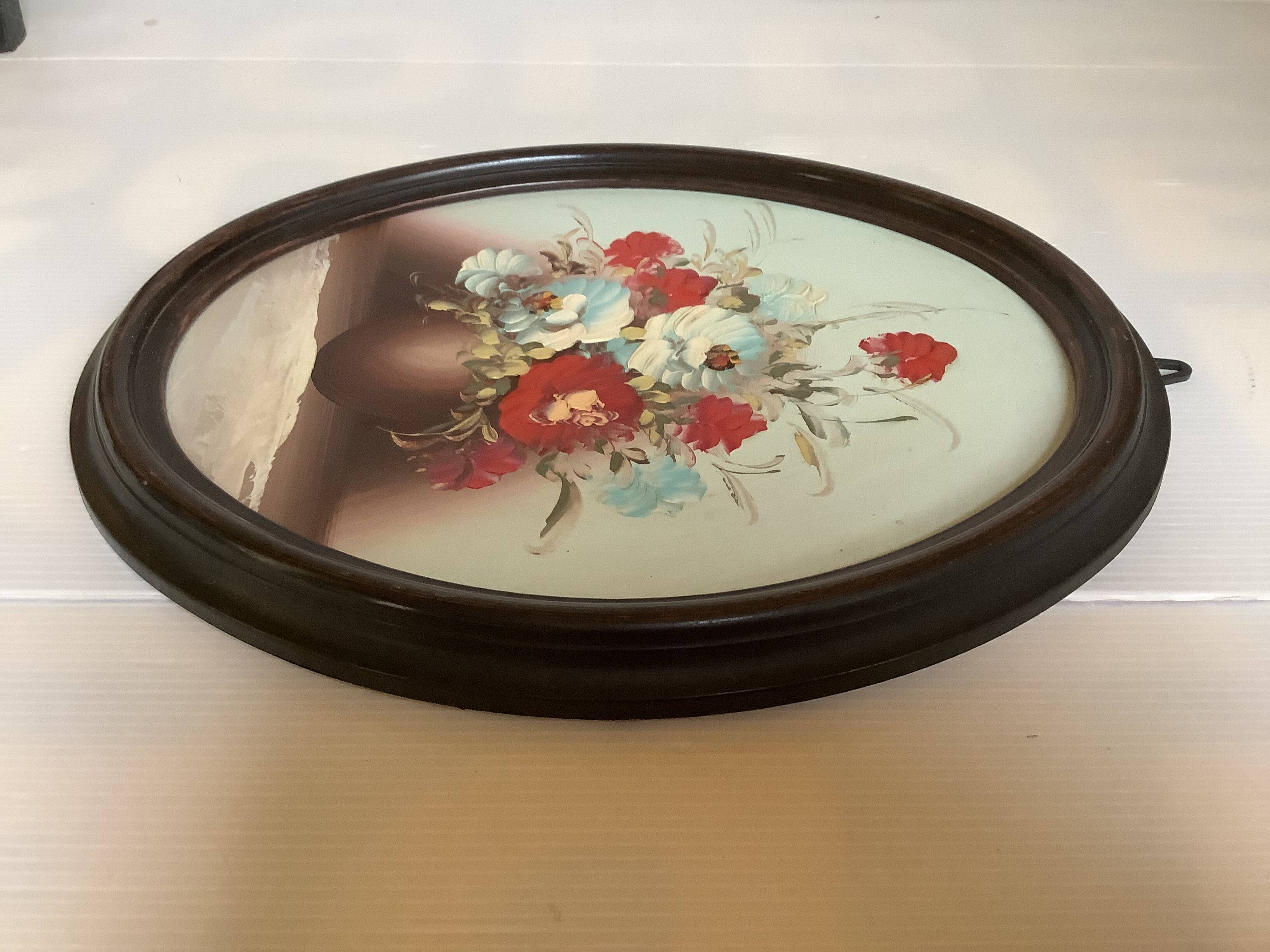 Oval painting of a bouquet of flowers, oil on panel.