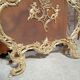 Large gilded bronze fireplace screen decorated with putti and rocaille motifs.