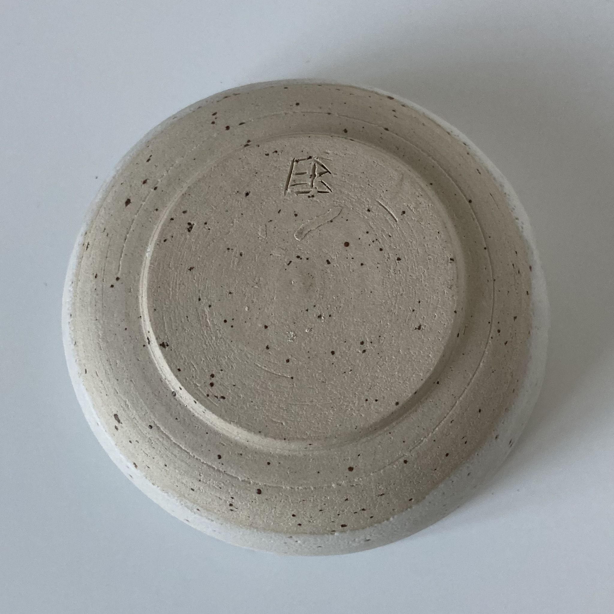 Meeting of three artist's ceramic objects including two pots and a cream covered bowl