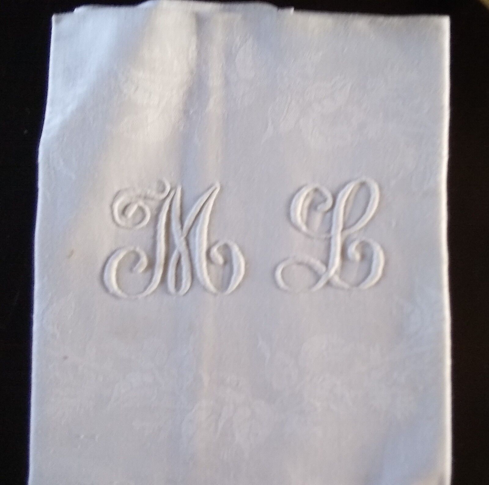 12 large antique damask towels with floral decoration and embroidered with the ML monogram