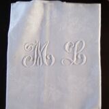 12 large antique damask towels with floral decoration and embroidered with the ML monogram