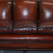 Restored Victorian sofa in leather with claw feet and feather cushions.