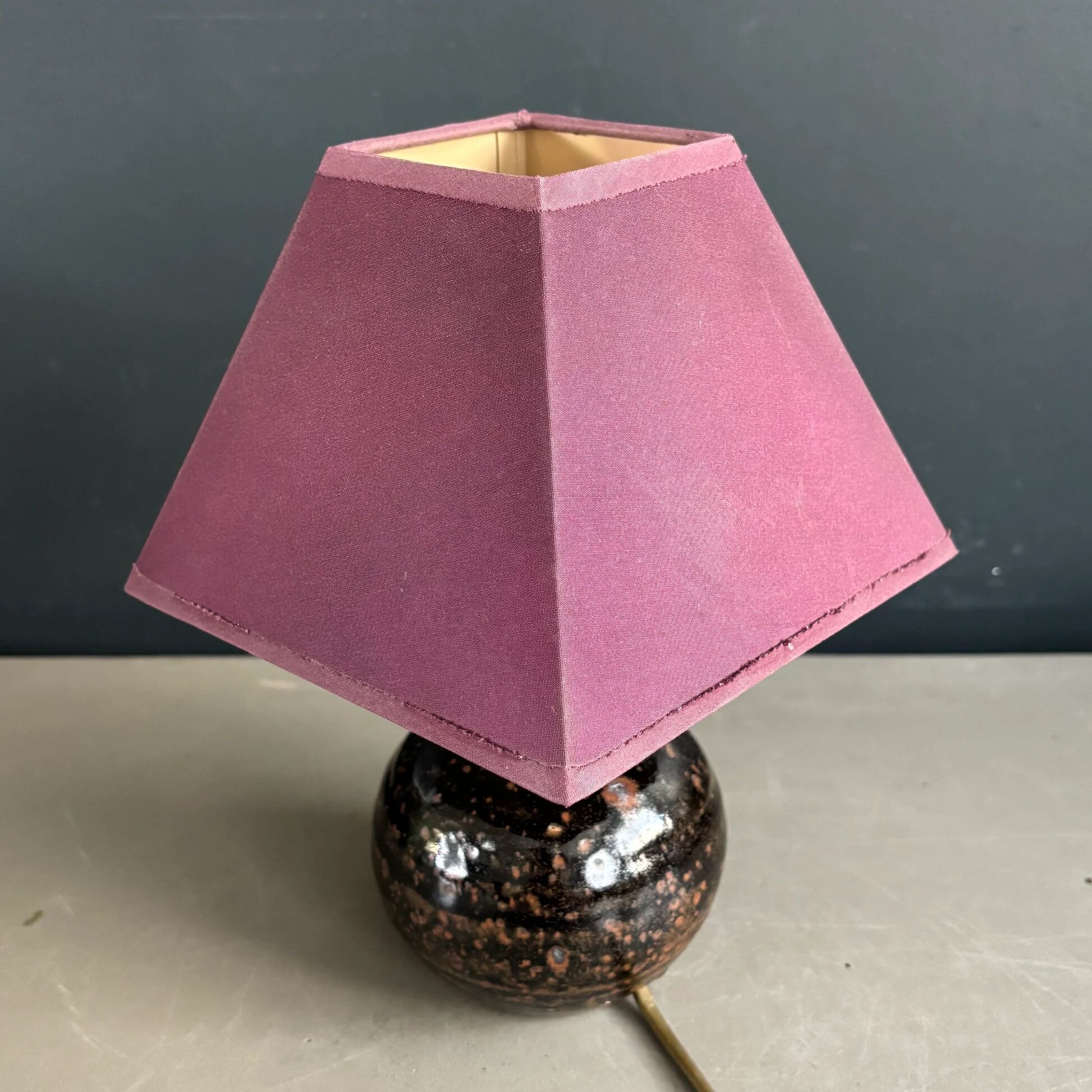 Ceramic floor lamp with a pyramidal shade and square base.