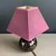 Ceramic floor lamp with a pyramidal shade and square base.
