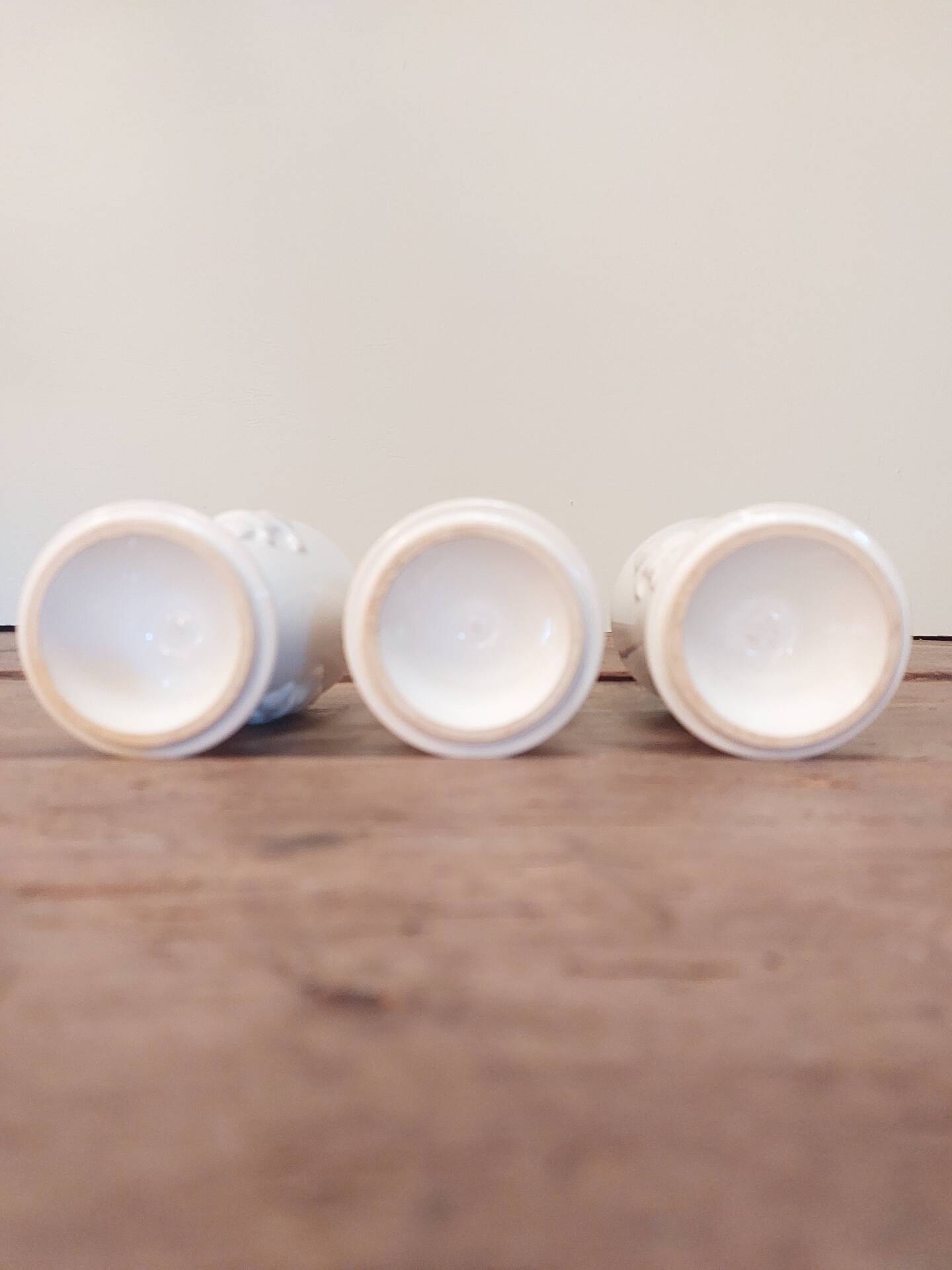 Three antique cups decorated with fleur-de-lis.