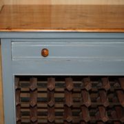 Vintage wooden furniture for 45 wine bottles with a drawer.