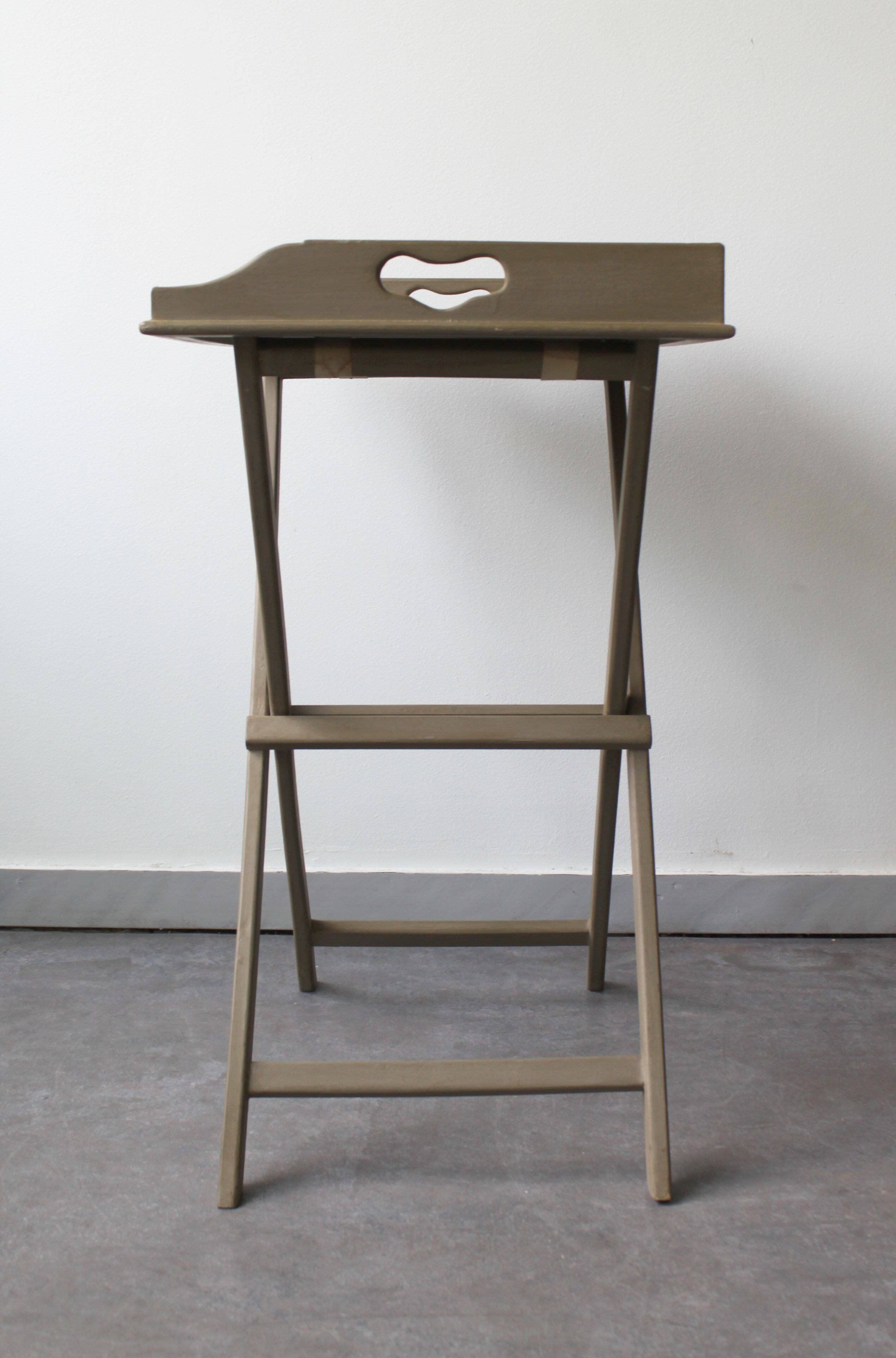 Folding and removable service tray in taupe-painted wood.
