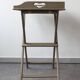 Folding and removable service tray in taupe-painted wood.