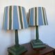 Pair of vintage wooden lamps with their striped beige, blue, and green shades.