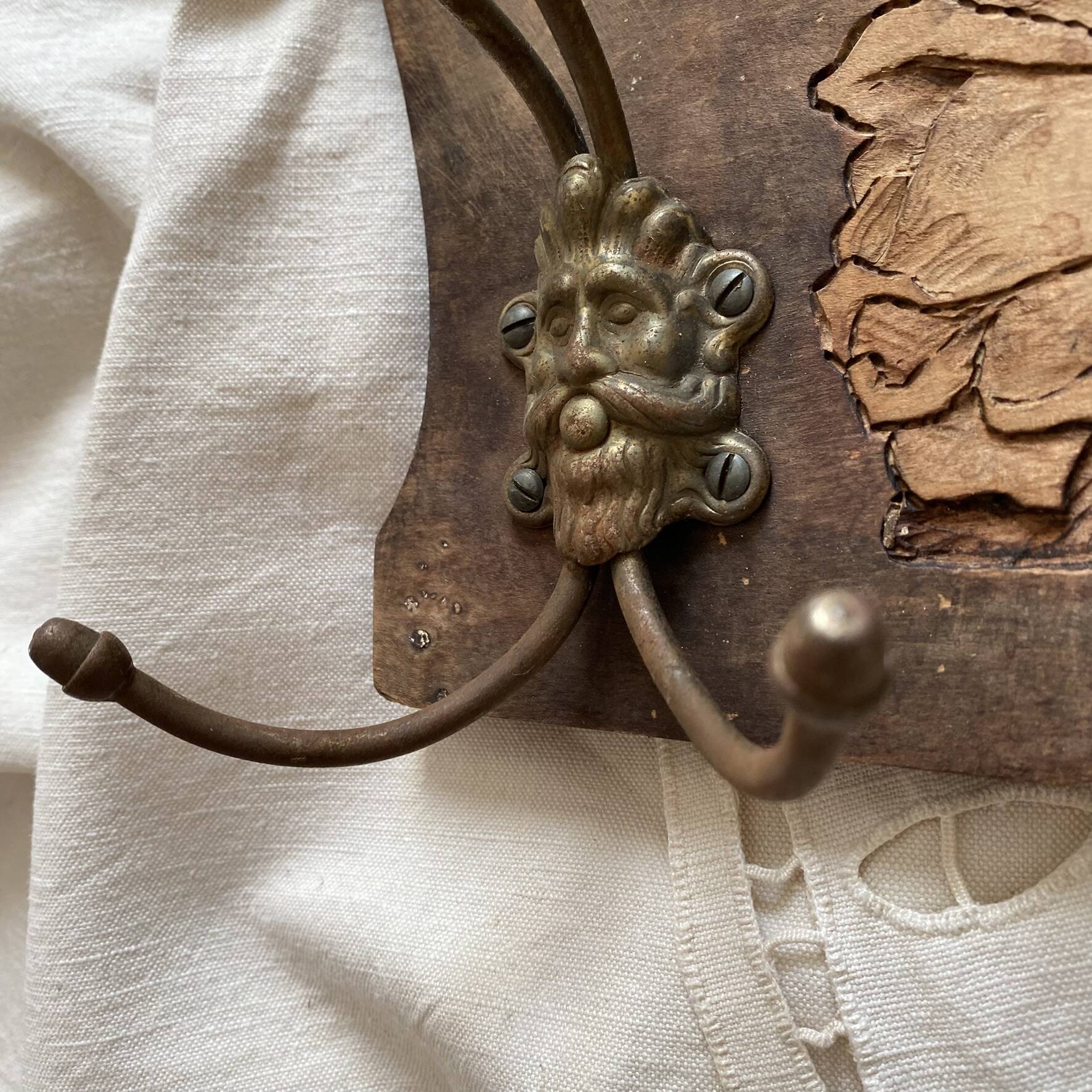 Wall-mounted coat rack in carved wood with rose decoration.