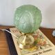 Art Deco green moulded glass globe table lamp with a brass base.