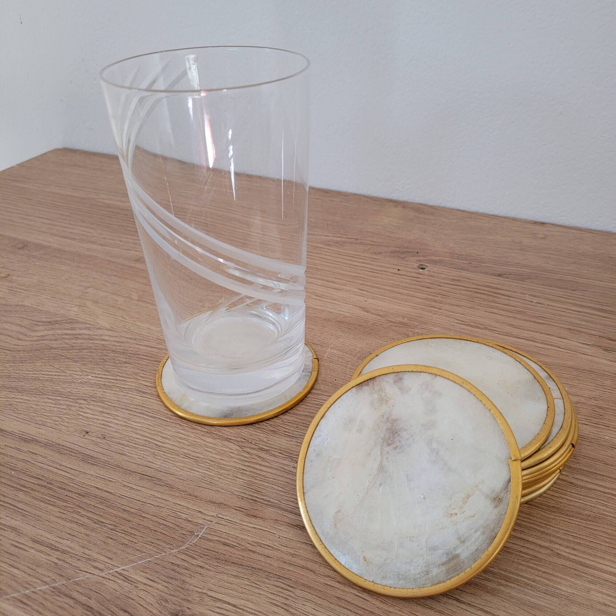Set of 11 mother-of-pearl coasters with brass rim.
