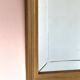 Miroir en bois doré, de forme organique avec une glace biseauté